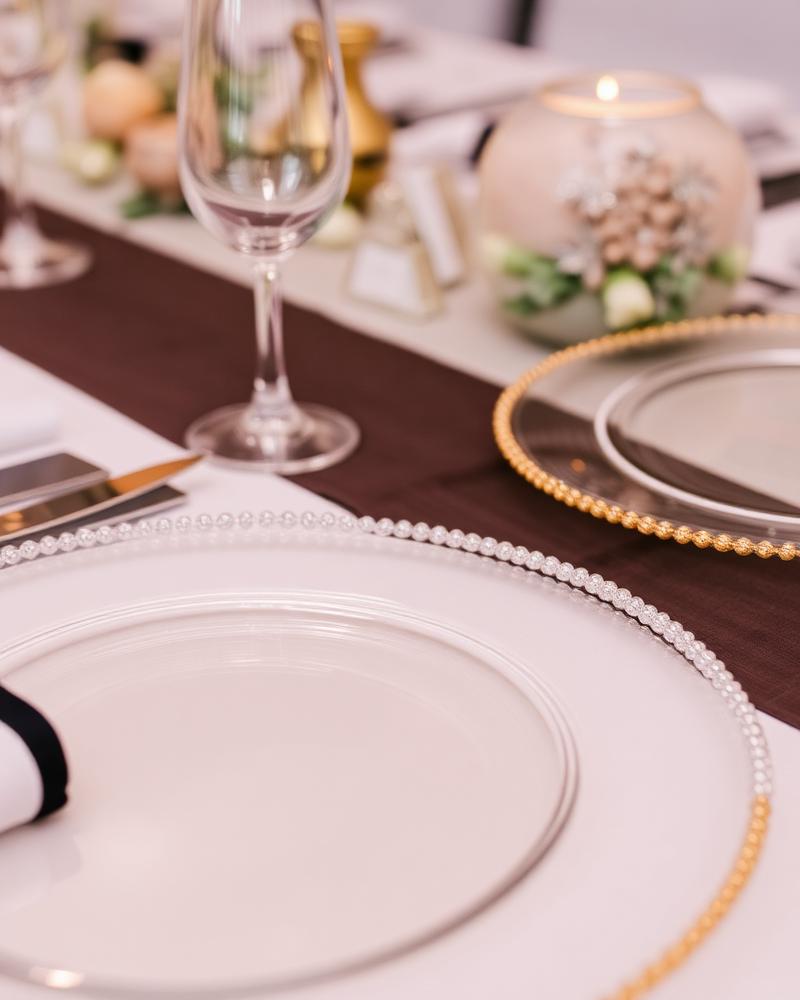 Beaded edge clear acrylic charger plates on a set table
